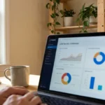 Tela de laptop exibindo gráficos de lead scoring, com planta ao fundo e caneca sobre mesa de madeira.